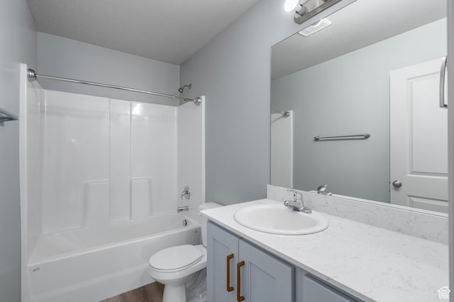 full bath featuring toilet, vanity, wood finished floors, and  shower combination