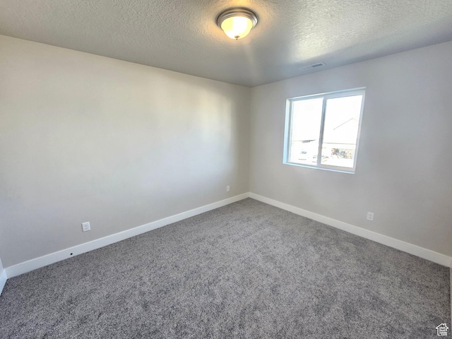 carpeted empty room with a textured ceiling, visible vents, and baseboards