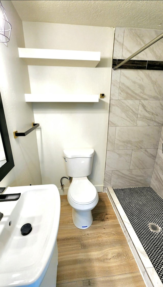 bathroom with toilet, a sink, and a stall shower