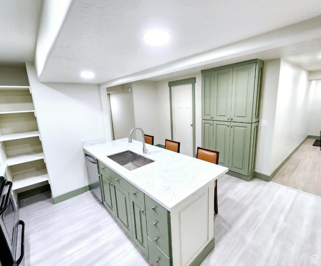 kitchen with dishwasher, a peninsula, green cabinetry, and a sink
