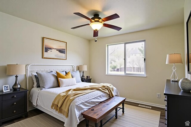 bedroom with wood finished floors, baseboards, and ceiling fan