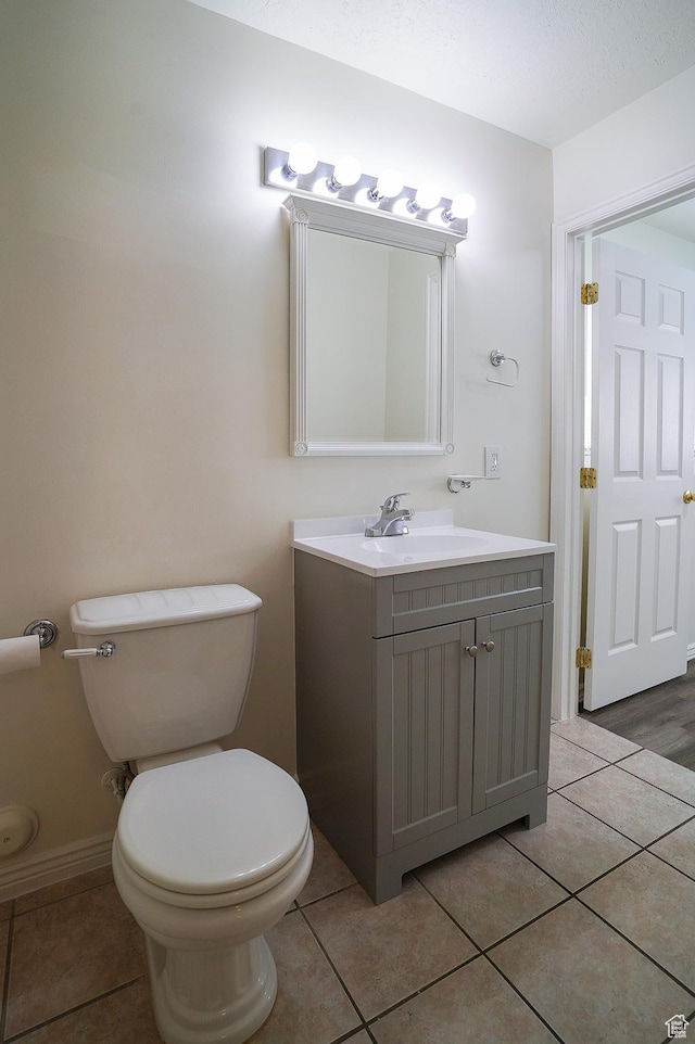 bathroom with tile patterned floors, toilet, and vanity