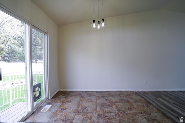 unfurnished dining area with stone finish flooring, baseboards, and vaulted ceiling
