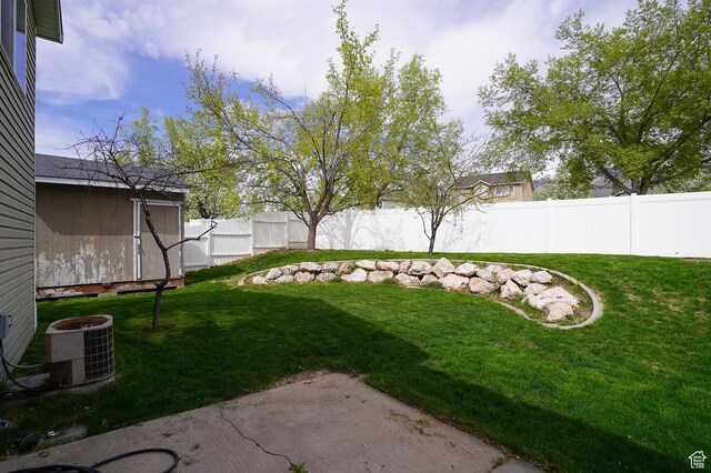 view of yard featuring an outbuilding, a patio area, and cooling unit