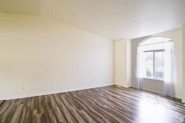 spare room with dark wood-style flooring and baseboards