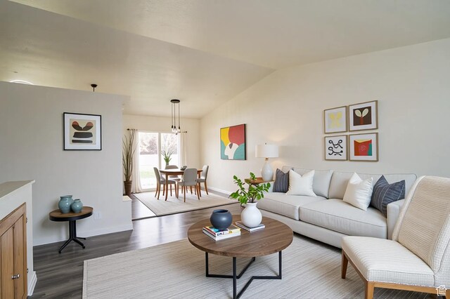 living room featuring lofted ceiling, baseboards, and dark wood-style flooring