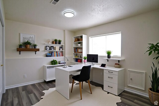 home office with dark wood-style flooring, a textured ceiling, and built in study area