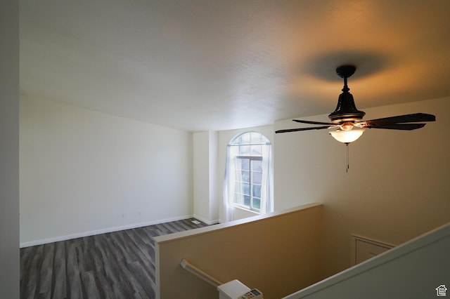 stairs with wood finished floors, ceiling fan, and baseboards