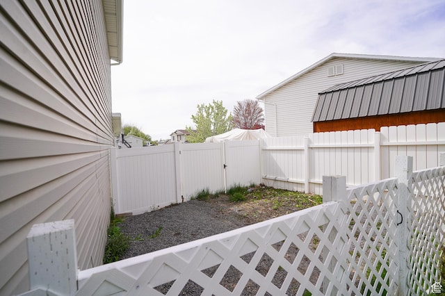 view of property exterior with a fenced backyard and a gate