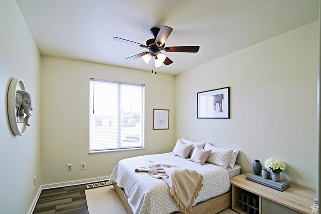 bedroom featuring wood finished floors, baseboards, and a ceiling fan