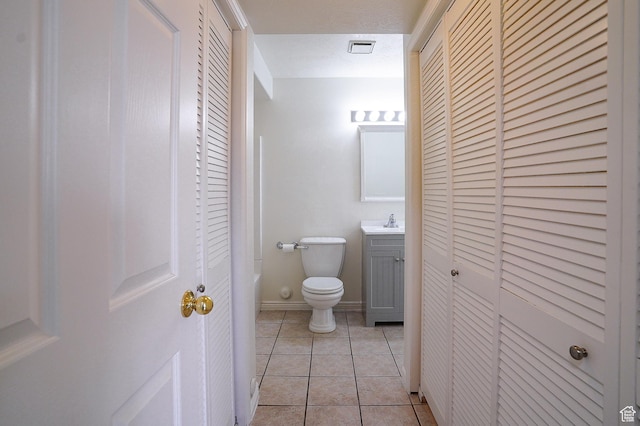 bathroom with a closet, toilet, and vanity