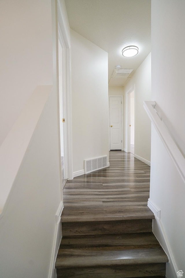 stairway with wood finished floors and baseboards