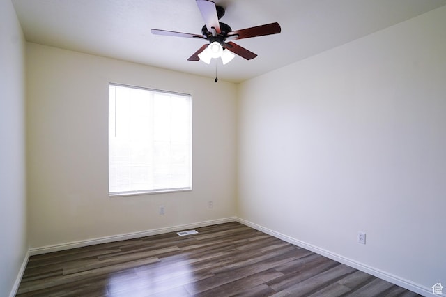 empty room featuring dark wood-style floors, ceiling fan, and baseboards
