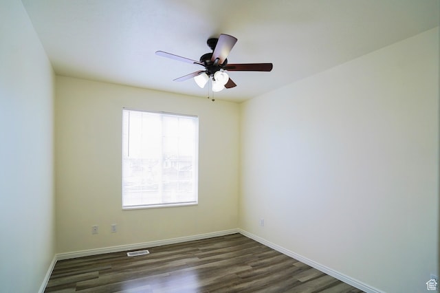 empty room with ceiling fan, dark wood-style flooring, and baseboards
