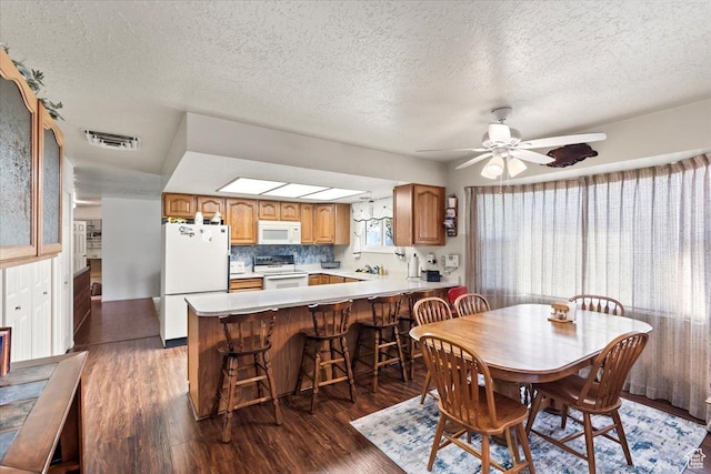 214 N Mountain Rd, Fruit Heights, UT 84037 - dining room featuring a textured ceiling, visible vents, a ceiling fan, and dark wood-style flooring