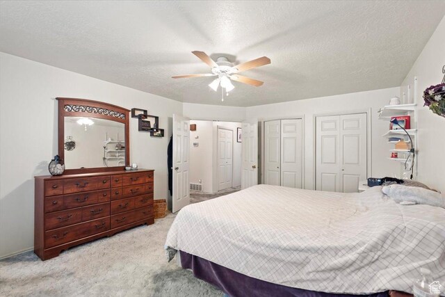 214 N Mountain Rd, Fruit Heights, UT 84037 - carpeted bedroom featuring two closets, a ceiling fan, and a textured ceiling