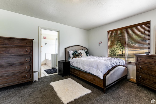 bedroom featuring dark colored carpet and ensuite bathroom
