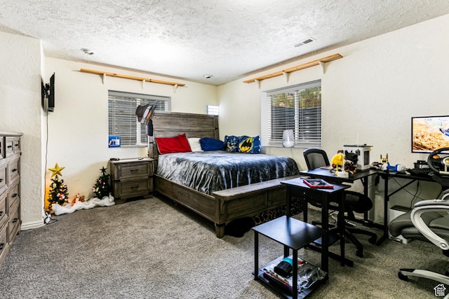 bedroom with a textured wall, visible vents, a textured ceiling, and carpet flooring