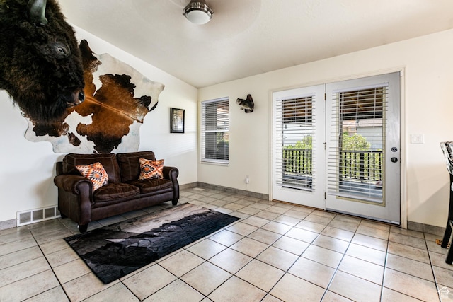 living area with baseboards, visible vents, and light tile patterned floors