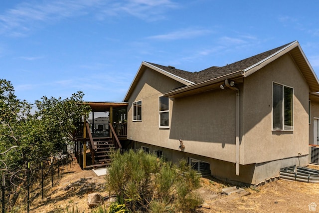 view of property exterior with stairway, a wooden deck, cooling unit, and stucco siding