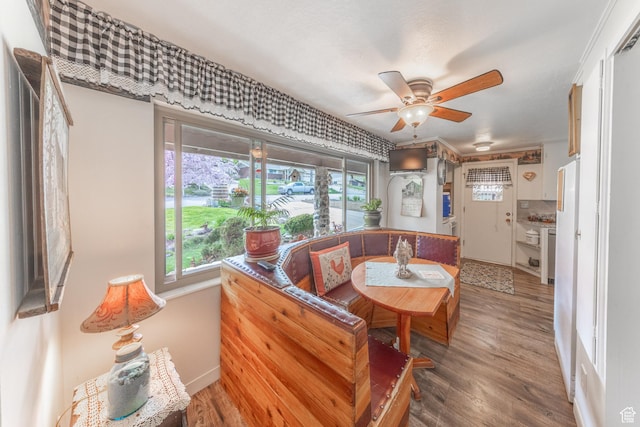 dining area with baseboards, a ceiling fan, and wood finished floors