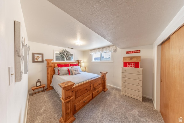 bedroom with baseboards, a closet, a textured ceiling, and carpet
