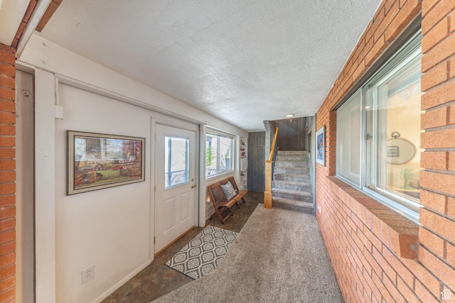 foyer featuring stairway and a textured ceiling