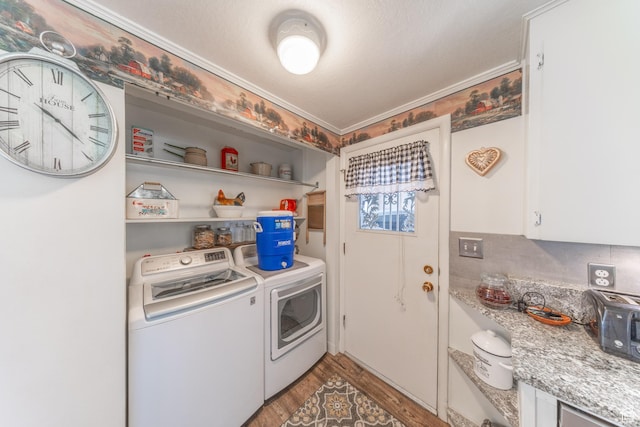 laundry area with washing machine and dryer, ornamental molding, light wood finished floors, and laundry area