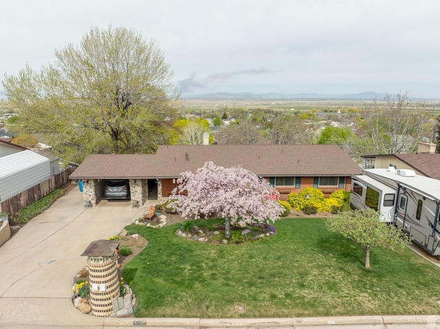 view of front of home featuring a carport, a front lawn, driveway, and a mountain view