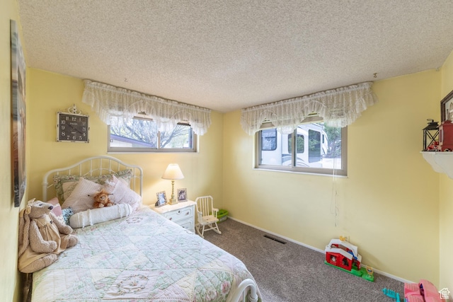 carpeted bedroom with baseboards and a textured ceiling