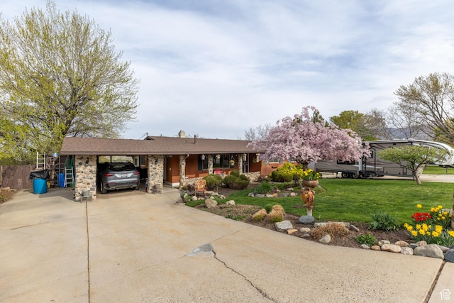 ranch-style house featuring a carport, a porch, a front yard, and concrete driveway