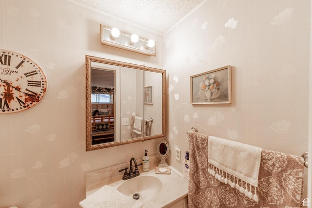 bathroom featuring a textured ceiling, crown molding, and vanity