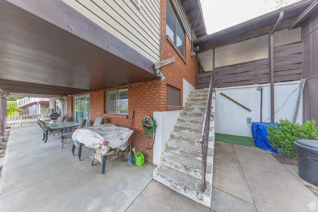 view of patio with outdoor dining area and stairway
