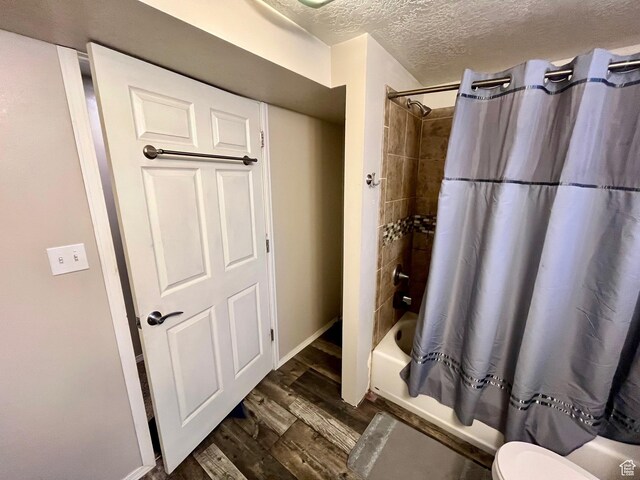 440 S 400 W, Preston, ID 83263 - full bath featuring wood finished floors, a textured ceiling, shower / tub combo with curtain, baseboards, and toilet