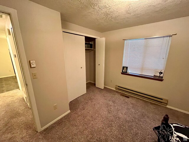 440 S 400 W, Preston, ID 83263 - unfurnished bedroom featuring a textured ceiling, a closet, a baseboard heating unit, carpet floors, and baseboards