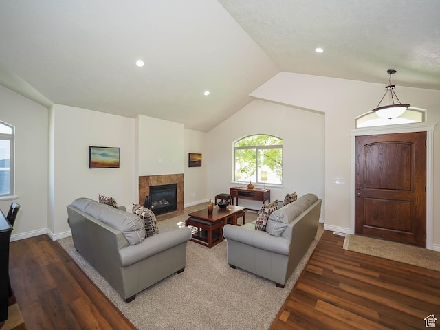 851 E Oak Ct Unit 28, Tooele, UT 84074 - living area with lofted ceiling, baseboards, a tile fireplace, and wood finished floors