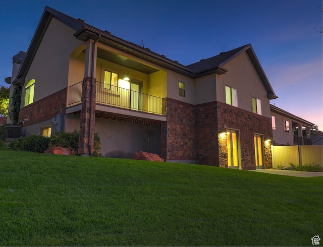 851 E Oak Ct Unit 28, Tooele, UT 84074 - view of front of house featuring stucco siding, a front lawn, stone siding, and a balcony