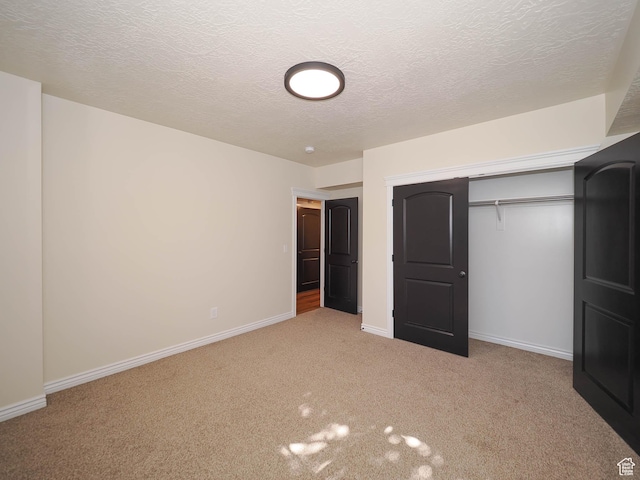 851 E Oak Ct Unit 28, Tooele, UT 84074 - unfurnished bedroom featuring a closet, carpet floors, a textured ceiling, and baseboards