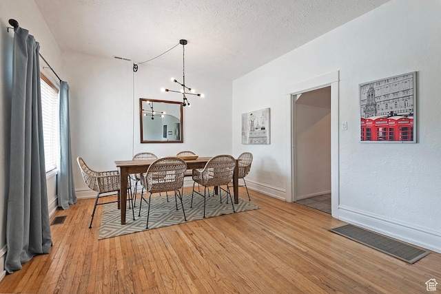 731 E Roosevelt Ave, Salt Lake City, UT 84105 - dining room featuring a chandelier, visible vents, light wood finished floors, and baseboards