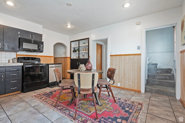 731 E Roosevelt Ave, Salt Lake City, UT 84105 - dining space with arched walkways, wooden walls, stairs, and wainscoting