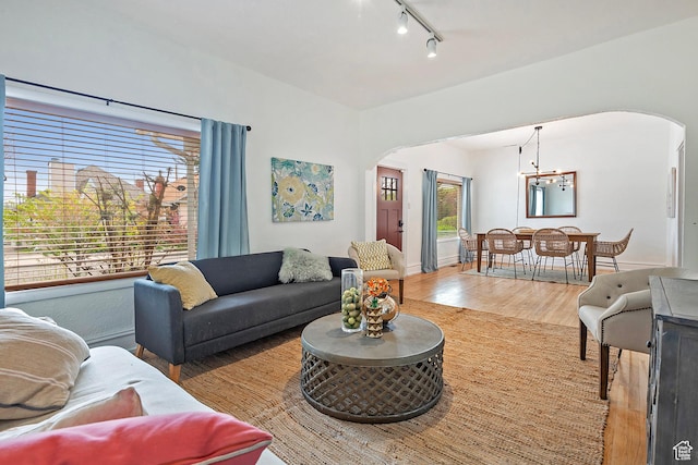 731 E Roosevelt Ave, Salt Lake City, UT 84105 - living area featuring an inviting chandelier, track lighting, wood finished floors, and arched walkways