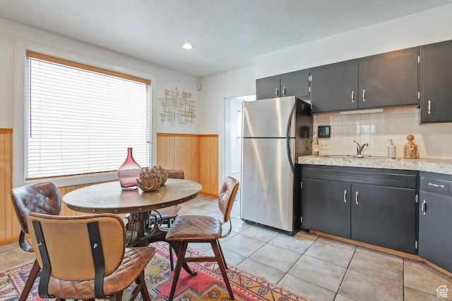 731 E Roosevelt Ave, Salt Lake City, UT 84105 - kitchen with a wainscoted wall, light countertops, a sink, freestanding refrigerator, and a textured ceiling