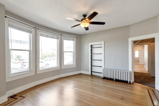 480 N 300 W, Salt Lake City, UT 84103 - unfurnished room featuring light wood-style floors, radiator heating unit, baseboards, and ceiling fan