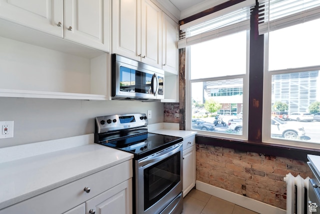 480 N 300 W, Salt Lake City, UT 84103 - kitchen featuring radiator heating unit, light tile patterned floors, light countertops, white cabinets, and appliances with stainless steel finishes