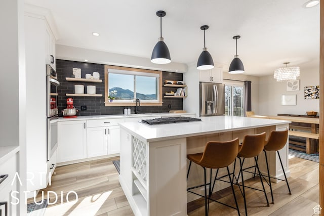 3116 N River Dr E, Eden, UT 84310 - kitchen with open shelves, backsplash, appliances with stainless steel finishes, and a center island