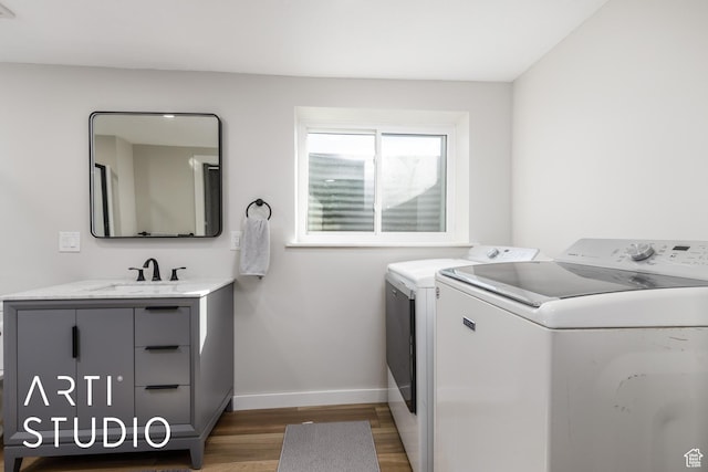 3116 N River Dr E, Eden, UT 84310 - washroom with wood finished floors, a sink, cabinet space, washing machine and dryer, and baseboards
