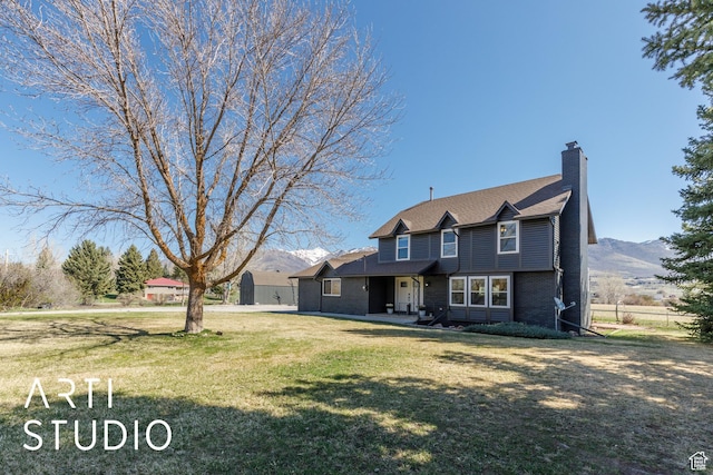 3116 N River Dr E, Eden, UT 84310 - view of front of property featuring a chimney, a front lawn, a mountain view, fence, and brick siding
