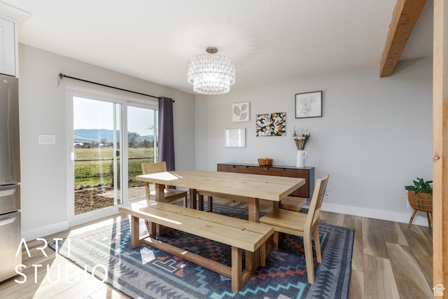 3116 N River Dr E, Eden, UT 84310 - dining area with light wood-style floors, a mountain view, beam ceiling, baseboards, and a notable chandelier