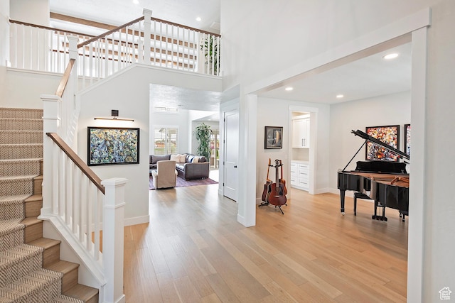 entrance foyer with stairway, baseboards, recessed lighting, and light wood-style flooring