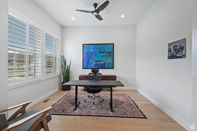 office space with baseboards, a ceiling fan, and light wood-style floors
